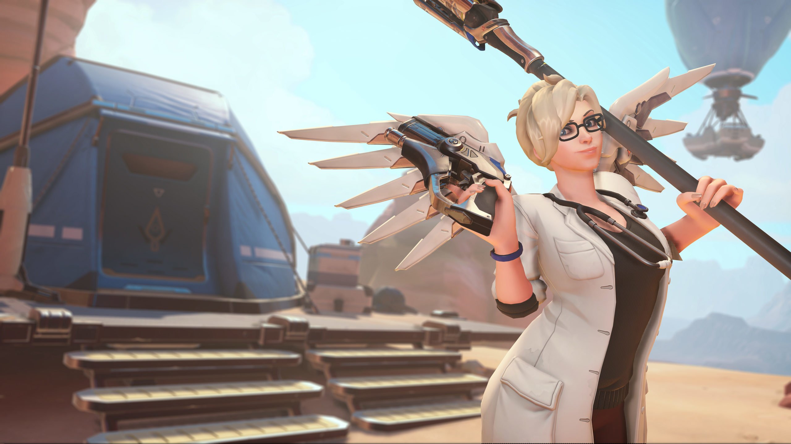 Mercy stands in front of Petra in a lab coat.