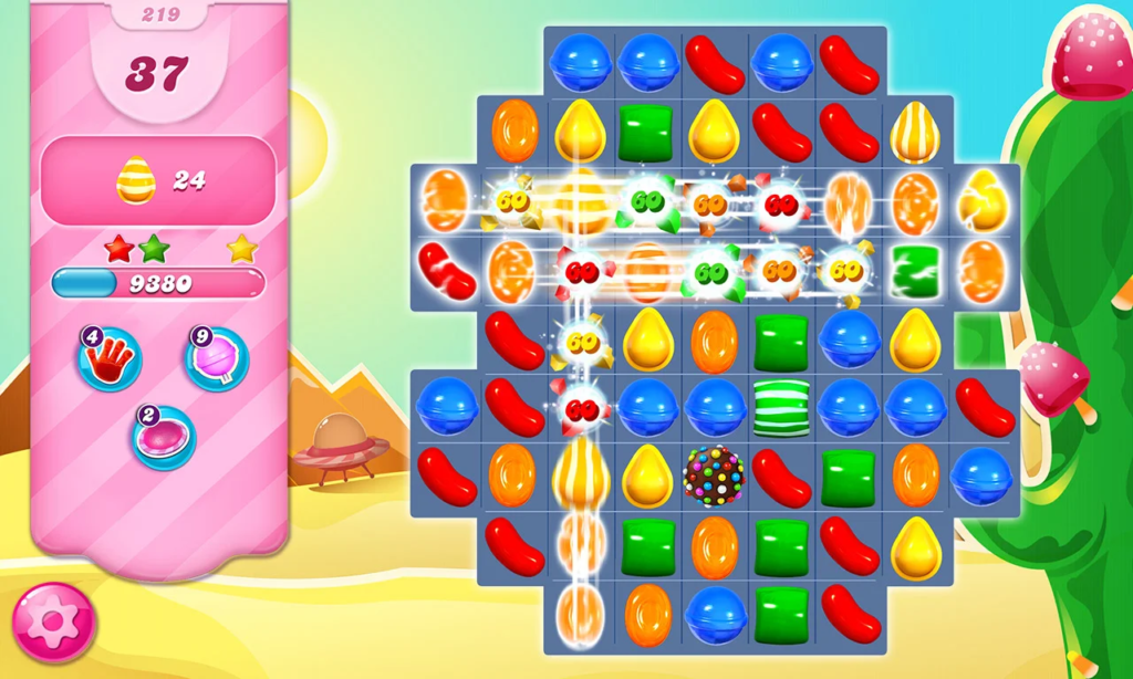  A screenshot of the game Candy Crush Saga, showing a board with colorful gems and powerups, with a desert landscape in the background.